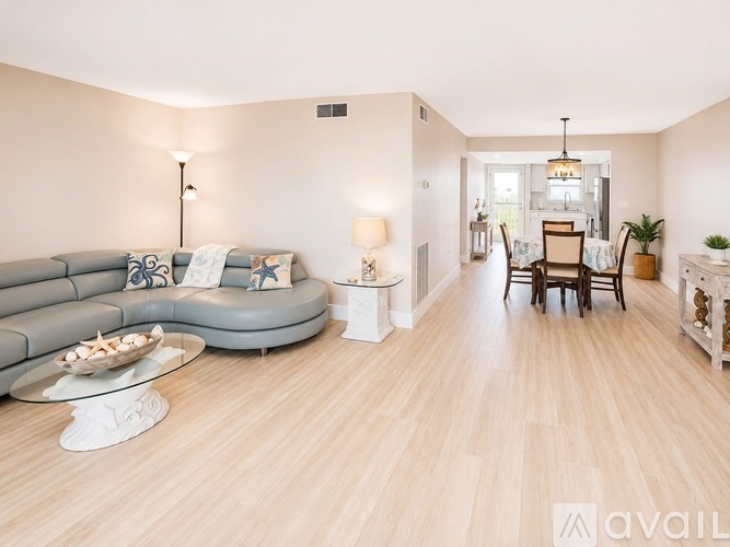 A living room with a grey couch and a wooden floor.