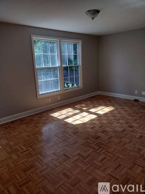 A room with a large window and wooden flooring.