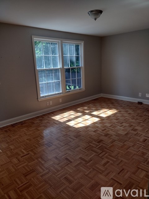 A room with a large window and wooden flooring.