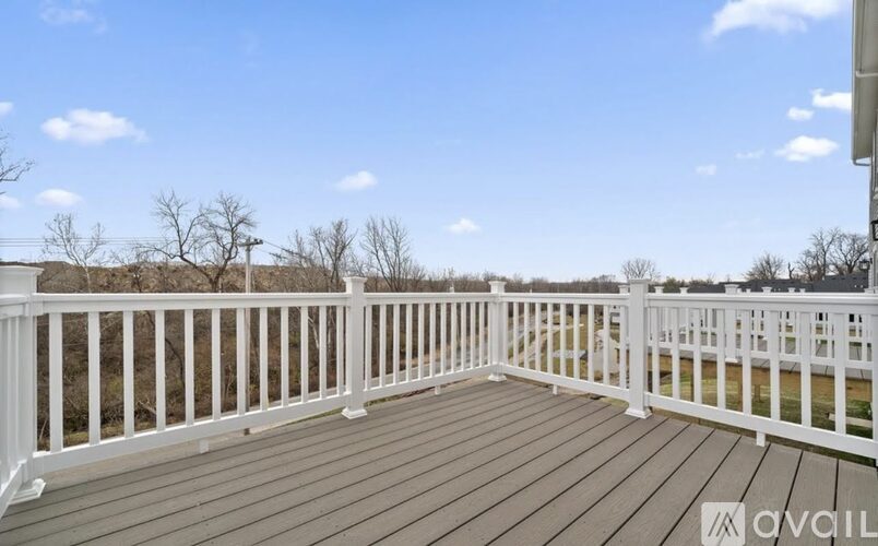 A deck with white railings and a wooden floor.