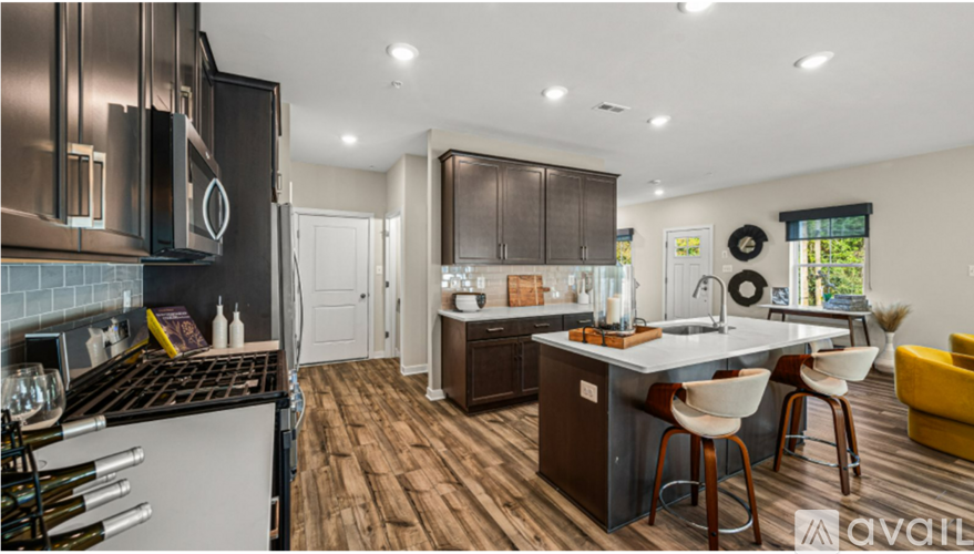 A modern kitchen with dark wood floors and a large island.