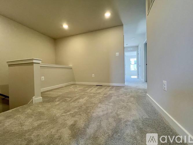 A spacious room with a carpeted floor and a fireplace.