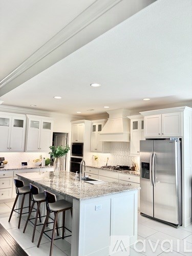 A kitchen with white cabinets and a granite countertop.