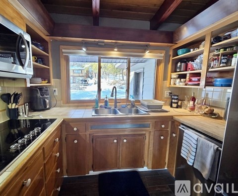 A kitchen with wooden cabinets and a stainless steel sink.