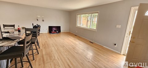 A living room with a fireplace and a dining table with chairs.