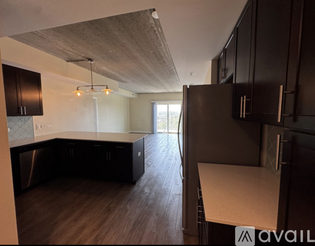 A kitchen with dark wood cabinets and a white countertop.