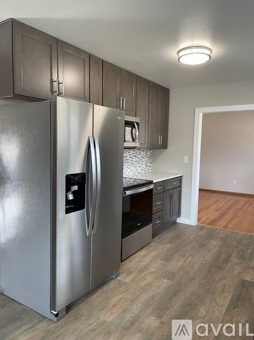 A modern kitchen with a stainless steel refrigerator and wooden cabinets.