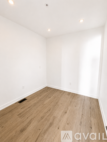 A room with wooden flooring and white walls.