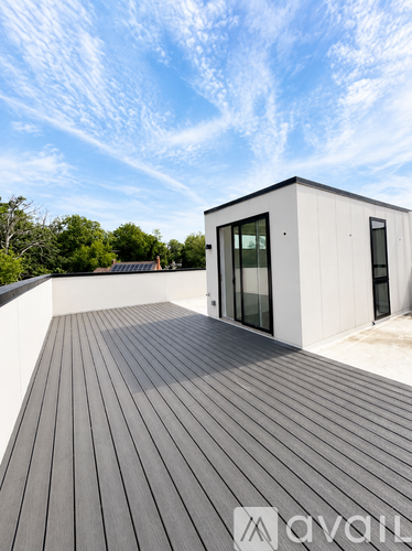 A modern house with a wooden deck and a white exterior.