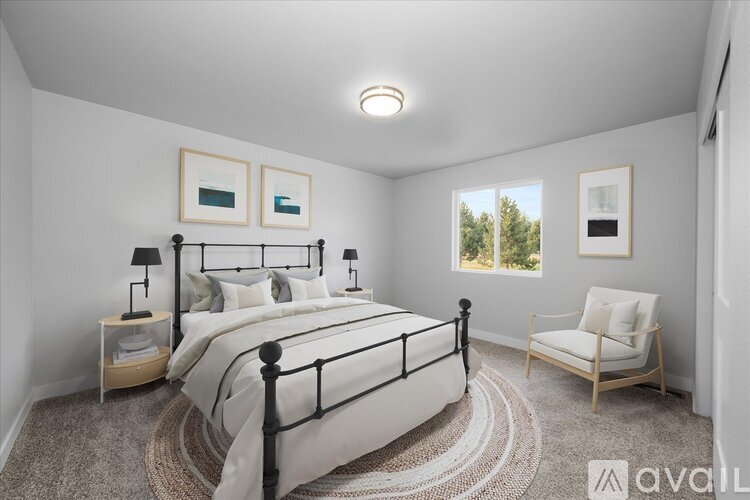 A bedroom with a large bed and a chair.