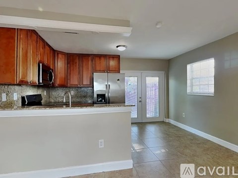 A kitchen with wooden cabinets and a countertop is available for rent.