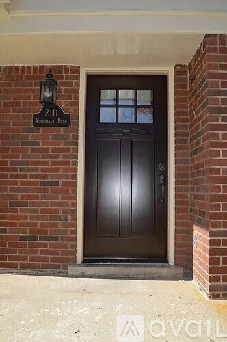 A brown door is on the right side of a brick wall.