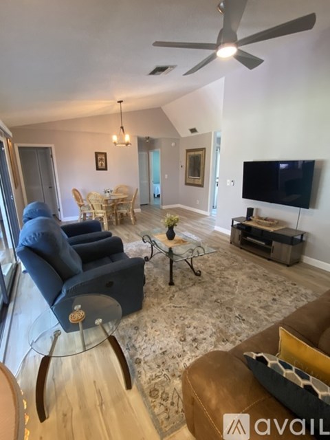 A living room with a blue chair and a brown couch.
