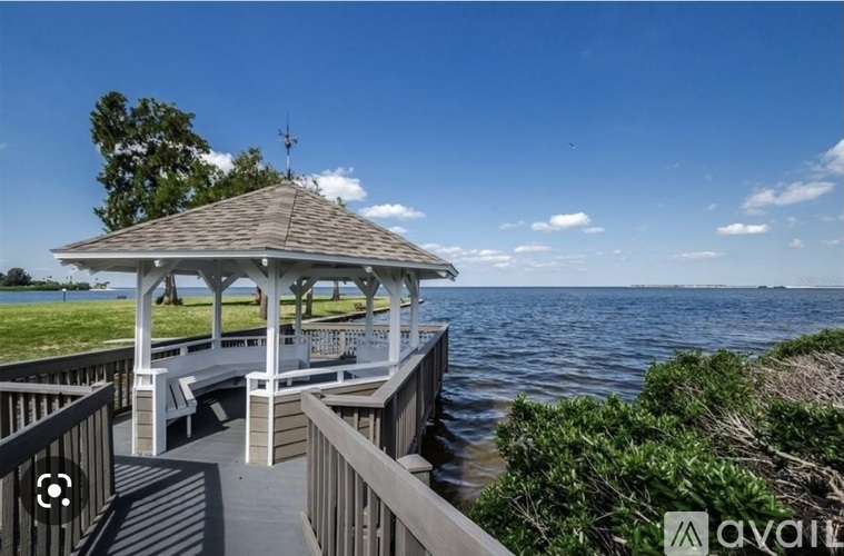 A gazebo is situated on a pier overlooking a body of water.