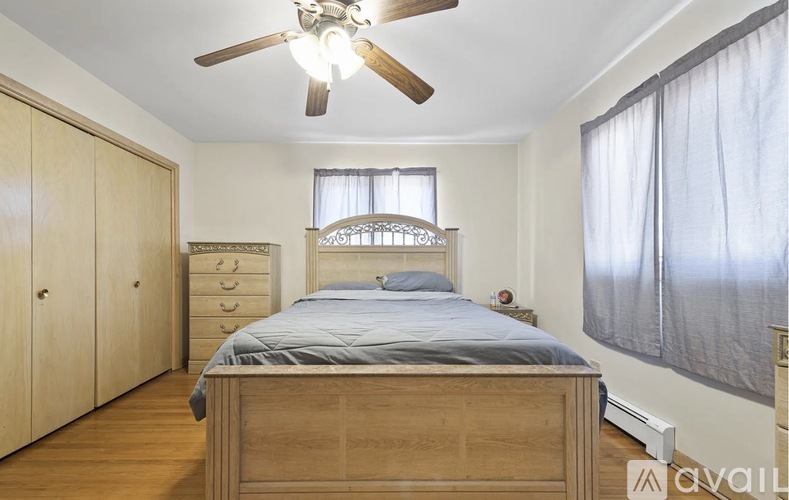 A bedroom with a bed, dresser, and wardrobe.