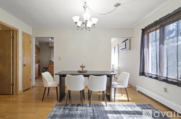 A dining room with a table and chairs.