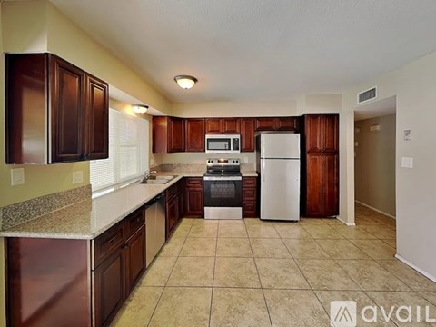 A kitchen with brown cabinets and a white refrigerator.
