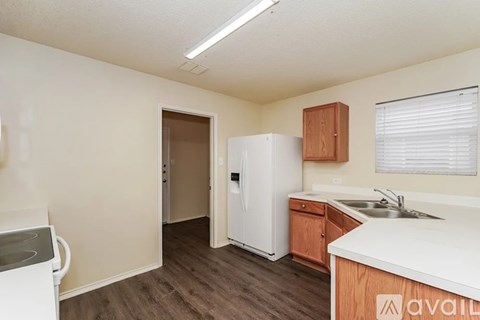 A kitchen with a white refrigerator and wooden cabinets.