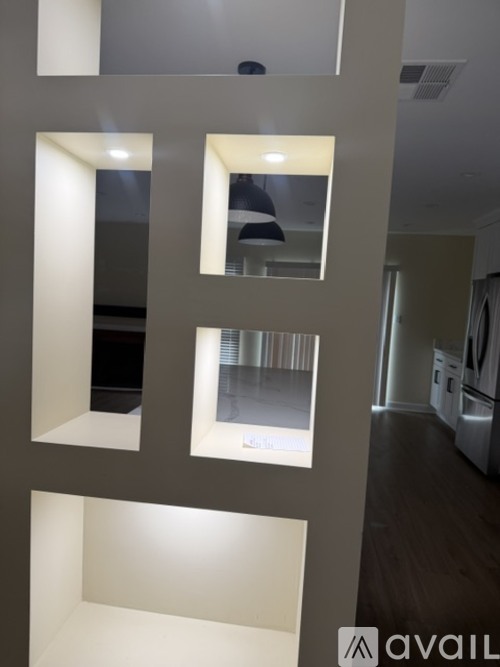 A modern interior space with a large mirror and a wall with cut-out sections.