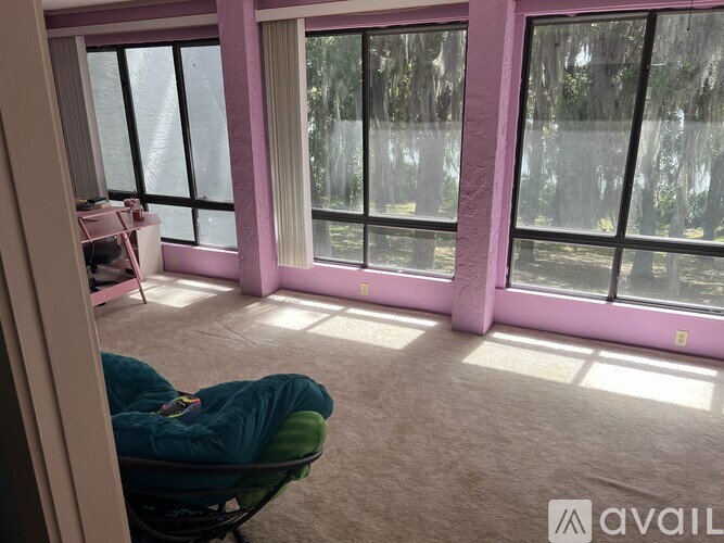 A person is sitting in a chair in a room with large windows.