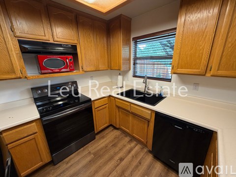 A kitchen with wooden cabinets and a red microwave.