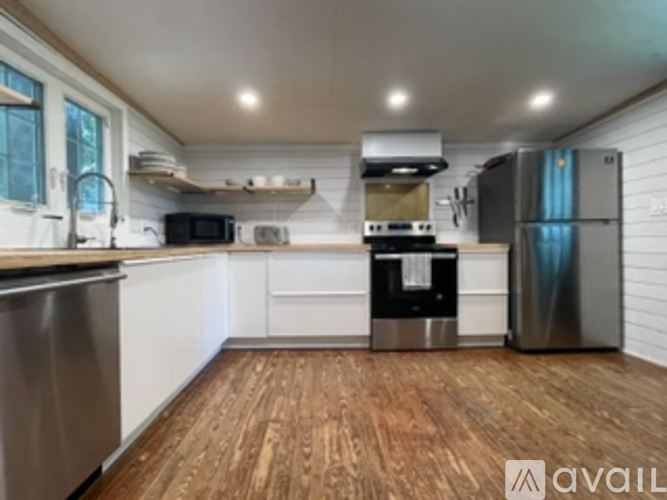 A kitchen with wooden floors and stainless steel appliances.