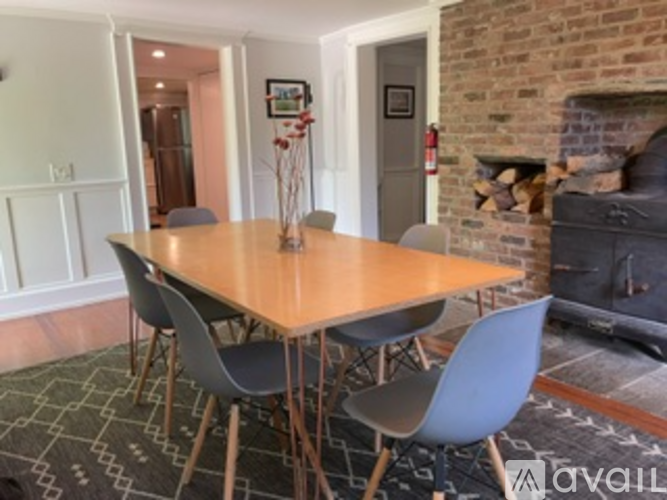 A dining room with a wooden table and grey chairs.