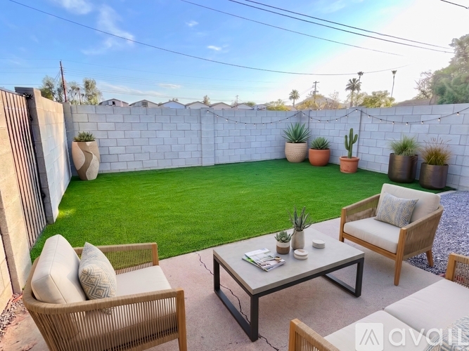 A patio with a table, chairs, and potted plants.