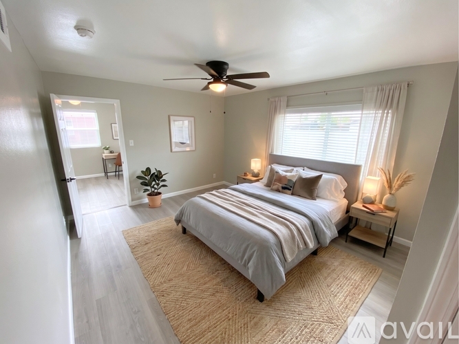 A bedroom with a large bed and a ceiling fan.