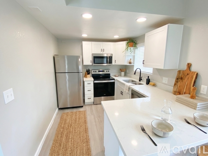 A kitchen with white cabinets and a stainless steel refrigerator.