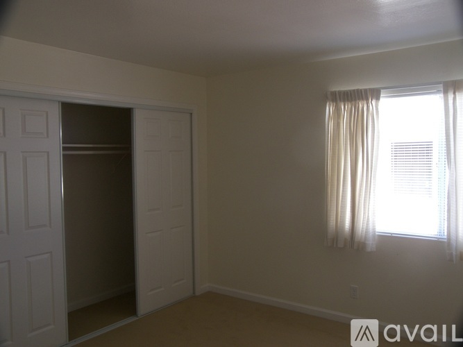 A room with a white door and a window with curtains.
