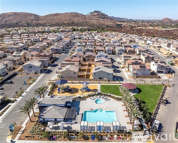A bird's eye view of a residential area with a swimming pool and a playground.