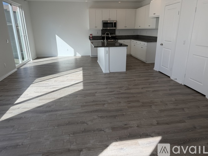 A kitchen with white cabinets and a black countertop is shown.