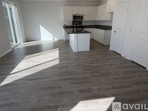 A kitchen with white cabinets and a black countertop is shown.