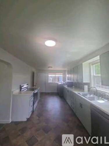 A kitchen with white appliances and wooden floors.