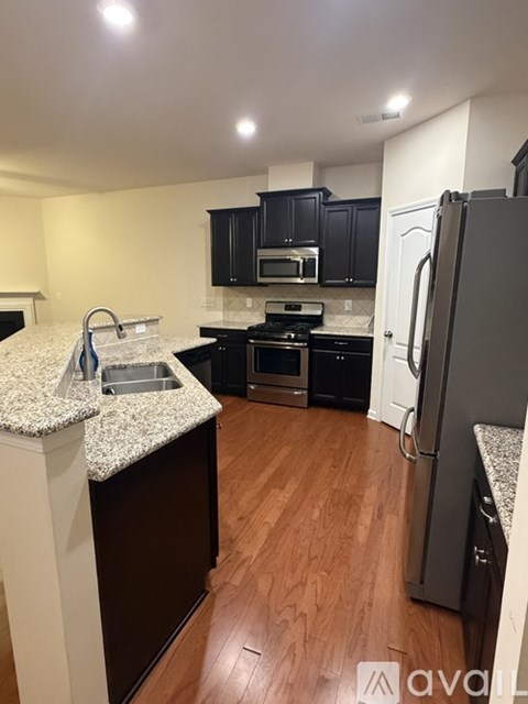 A kitchen with a granite countertop and a refrigerator.