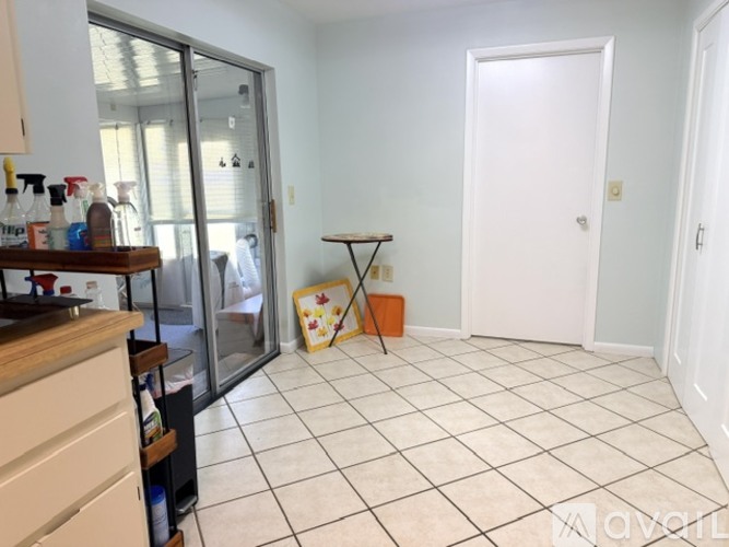 A kitchen with a white tile floor and a white door.