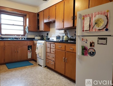 A kitchen with wooden cabinets and a white fridge.