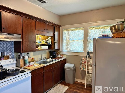 A kitchen with wooden cabinets and a white stove top oven.