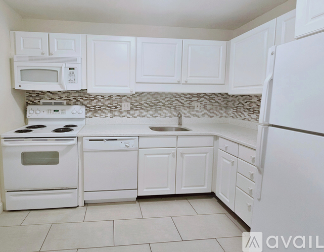 A kitchen with white appliances and cabinets.