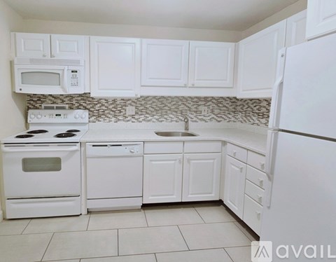 A kitchen with white appliances and cabinets.