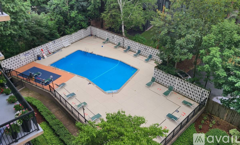 A small pool surrounded by a fence and trees.