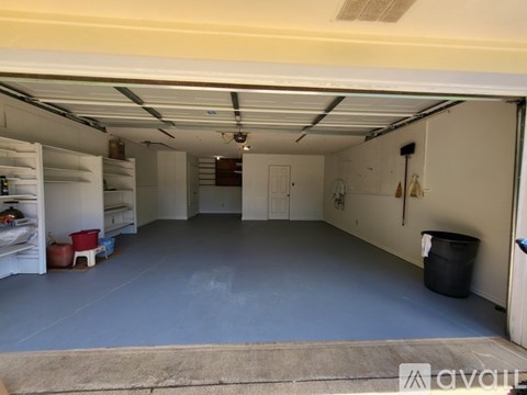 A large, empty garage with a blue floor and white walls.