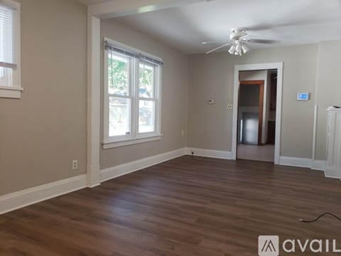 A room with wooden flooring and a ceiling fan.