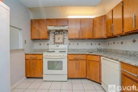 A kitchen with wooden cabinets and a white oven.