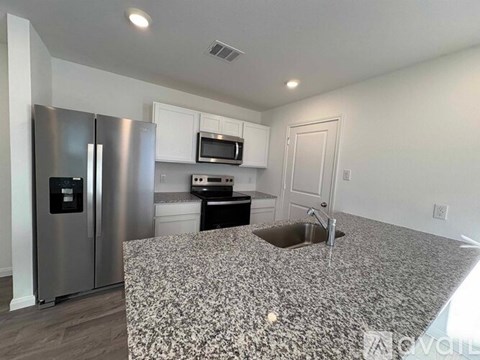 A kitchen with granite countertops and stainless steel appliances.