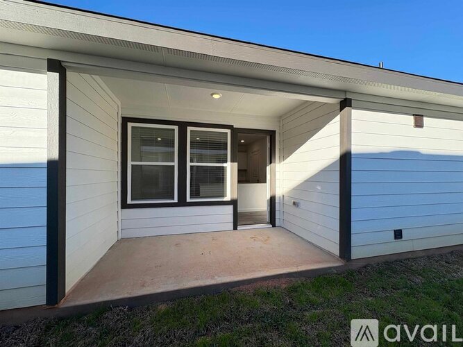 A house with a white exterior and a large window is available for purchase.