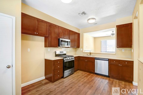 A kitchen with wooden cabinets and a stove top oven.
