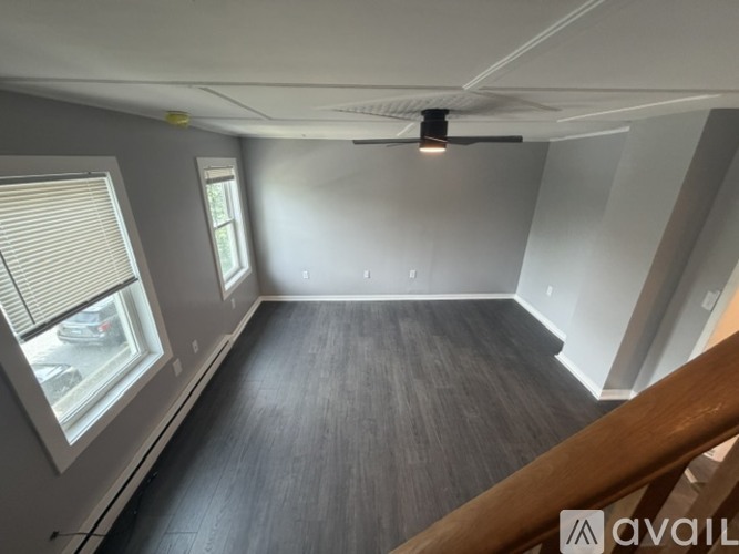 A room with a wooden floor and a ceiling fan.