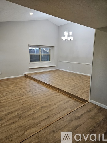 A room with wooden flooring and a window.
